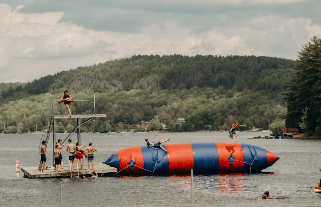 Photo courtesy of Word of Life - Students playing on blog in a lake
