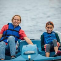 IMAGE: If you ever get the chance - counselor and camper in pedal boat